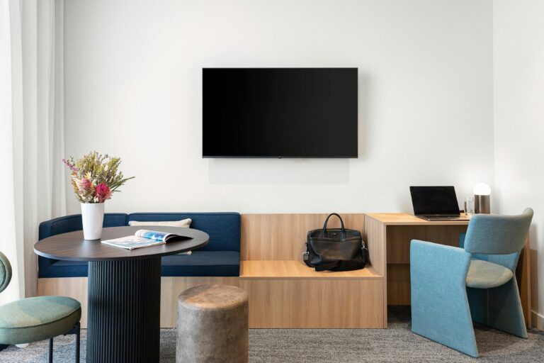 view of tv, table, desk and luggage rest