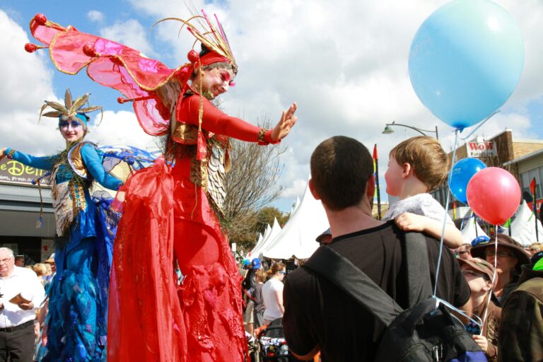 Festival entertainers on stilts with dad and child