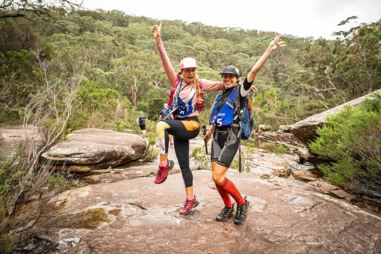 Two teammates pose mid-race together in the Royal National Park Bushland