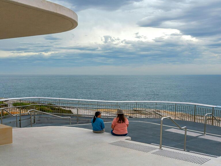 People looking out over the ocean from the whale watching platform at Cape Solander. Photo: John