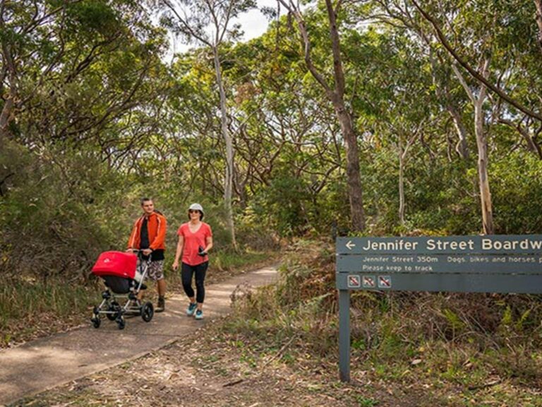 People walking and pushing their pram along the Jennifer Street boardwalk, La Perouse area, Kamay